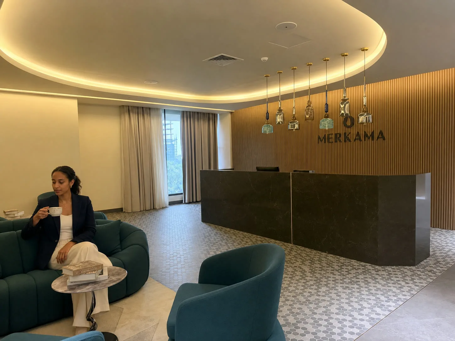 A guest pausing over coffee in Merkama's reception lounge